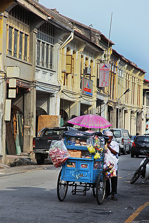 A roti man selling bread with the traditional cart in Geprgetown