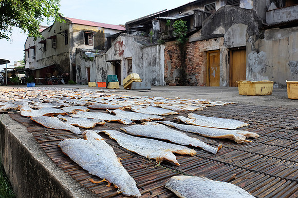 A rare scene within the Georgetown : Drying salted fish in the middle of the town